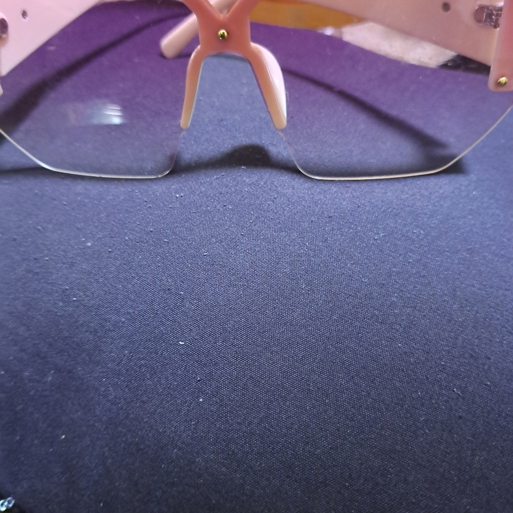 Unixex glasses, with white legs and tinted pink lenses with gold edges, news ,